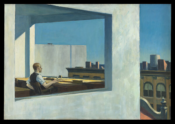 A man in a sunlit corner office overlooking city rooftops.